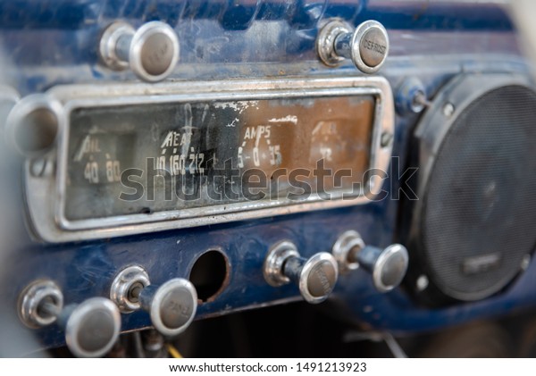Dashboard at front of abandoned vintage\
truck with ammeter, oil indicator, various\
knobs