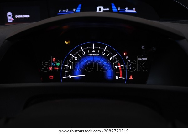 The\
dashboard of a sedan; all indicators lights are\
on.