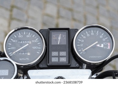 Dashboard of a vintage motorcycle. Visible: speedometer, tachometer and odometer.Chrome gauges (