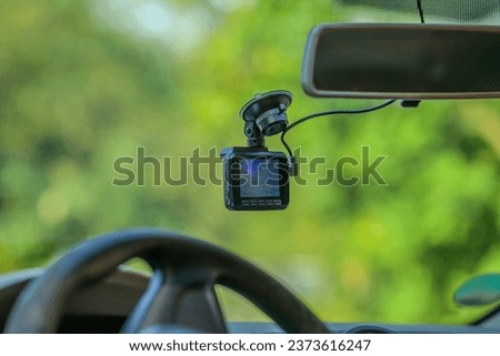 A dashcam on the windshield of a car