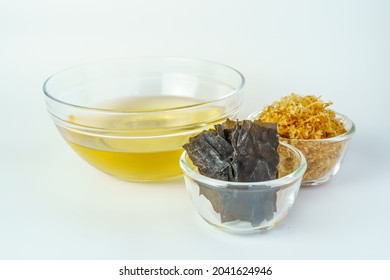 Dashi Or Japanese Soup Stock In The Glass Bowl With The Ingredients For Cooked Dashi Such As Kombu And Katsuobushi (Japanese Seaweed And Dried Smoked Skipjack Tuna) Isolated On White Background.