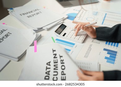 Data Analysis. Accountant using calculator to analyze financial reports and documents.