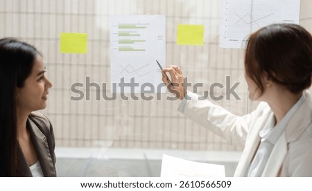 Data Analysis and ESG Evaluation. Two professionals review statistics on sustainable practices.