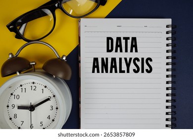 Data Analysis text written on notepad with alarm clock on blue background