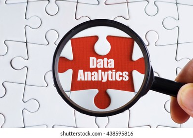 "Data Analytic" text on red missing jigsaw puzzle with man right hand hold black magnifying glass searching for missing puzzle peace - business and finance concept