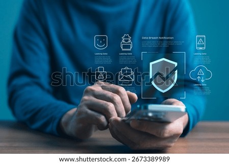Data breach notification concept on smartphone with hand holding device, showing shield icon and warning symbols, for cybersecurity risk, data leak, identity theft, and mobile threat