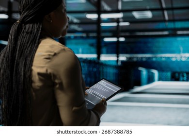 Data center admin uses tablet to monitor hardware for potential failures, improving system stability. Server hub IT professional configures supercomputers settings with device to increase uptime