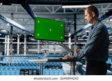 Data center admin using green screen PC to do programming, optimizing resource allocation. Man in server room uses mockup computer, upgrading components for increased processing and storage capacity