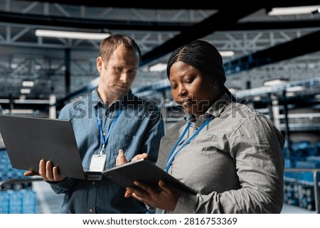 Data center administrators scan equipment for errors and back up supercomputer data using connected devices and laptop software, supporting system maintenance, data backup, and network reliability.