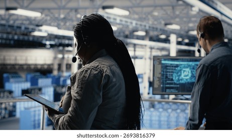 Data center colleagues using artificial intelligence to help customers resolve website hosting problems. Server room tech support coworkers help users keep internet services running smoothly, camera B
