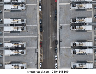 Data center complex featuring numerous servers and cooling units with vehicles parked nearby