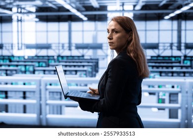 Data center computer scientist ensuring safety and security of database using notebook. Cybersecurity specialist in server farm preventing unauthorized access posing risks for business