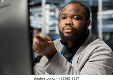 Data center computer scientist inspecting gear, doing maintenance tasks. Server farm worker looking at PC screen, conducting system checks to ensure operational stability across network rackmounts