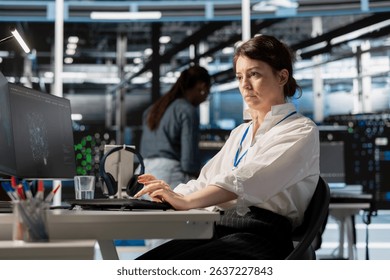 Data center computer scientist uses PC to update servers tech, configuring gear using software. Server hub IT professional reviewing hardware analytics, ensuring reliable network operations
