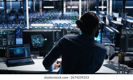 Data center computer scientist using PC to monitor neural network using AI LLM. IT expert at work using artificial intelligence to oversee servers powering machine learning, camera A