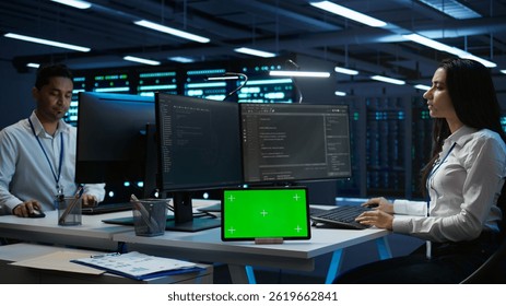 Data center developer responsible for installation of networking equipment solving tasks on green screen device. Woman doing maintenance on server room infrastructure using chroma key tablet, camera B