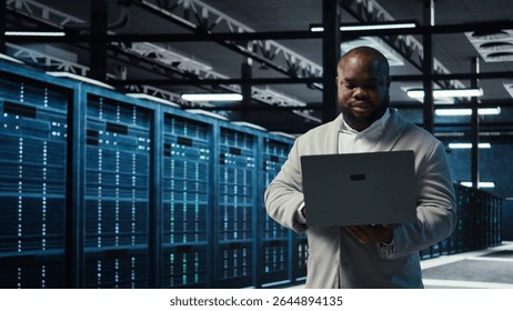 Data center engineer analyzing equipment performance, resolving technical issues. Server farm employee doing job tasks, overseeing operations, implementing efficiency optimizations, camera A