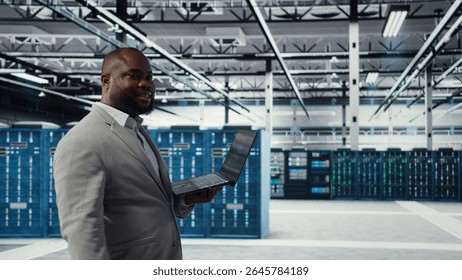 Data center engineer deploying AI driven management tools using laptop. Server farm employee inspecting server clusters, updating network topologies using artificial intelligence, camera A