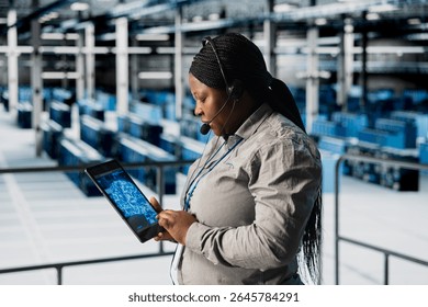 Data center engineer dispatching field technicians after doing AI system scans using tablet. Female technical support specialist in server room managing live support calls during server errors