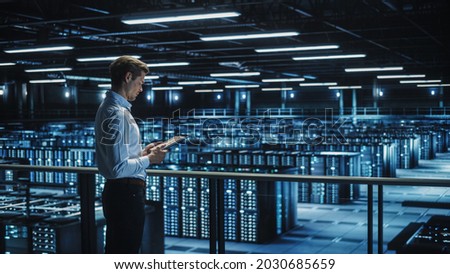 Data Center Engineer Using Digital Tablet Computer, Maintenance Specialist. High-Tech Information Protection, Cyber Security. Cloud Computing Facility. Server Farm for Iaas, saas, paas.