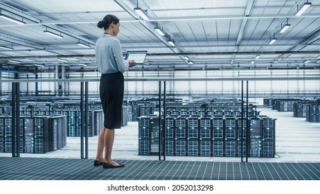 Data Center Engineer Using Laptop Computer. Server Farm Cloud Computing Specialist Facility with Multiethnic Female System Administrator Working with Data Protection Network for Cyber Security. - Powered by Shutterstock