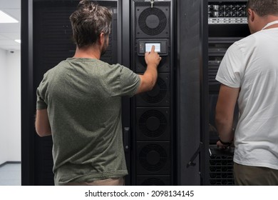 Data Center Engineer Using Laptop Computer. Server Room Specialist Facility with Korean Male System Administrator Working with Data Protection Network for Cyber Security.