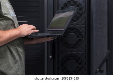 Data Center Engineer Using Laptop Computer. Server Room Specialist Facility with Korean Male System Administrator Working with Data Protection Network for Cyber Security.
