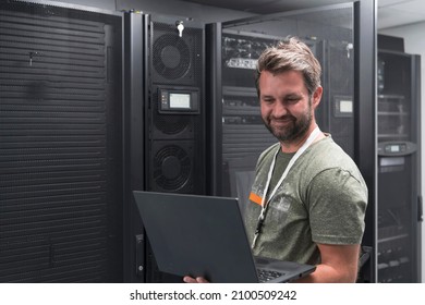 Data Center Engineer Using Laptop Computer Server Room Specialist Facility with Male System Administrator Working with Data Protection Network for Cyber Security or Cryptocurrency Mining Farm.