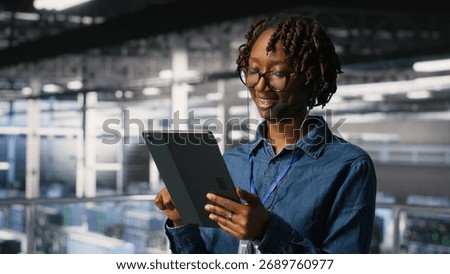 Data center engineer wearing headset microphone providing remote diagnostics using tablet. Technician monitors system health and guides users through infrastructure troubleshooting steps
