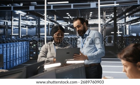 Data center engineering team colleagues collaborating on blade servers maintenance to ensure continuous AI processing. Technicians manage infrastructure supporting machine learning pipelines, camera A