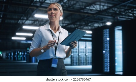 Data Center Female e-Business Entrepreneur Use Tablet Computer with Pleasure Smile. Information Technology Engineer and System Administrator work in Big Cloud Computing Server Farm. - Powered by Shutterstock