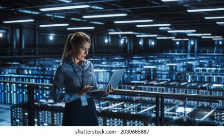 Data Center Female It Specialist Using Laptop. Server Farm Cloud Computing And Cyber Security Maintenance Administrator Working On Computer. Information Technology Professional.