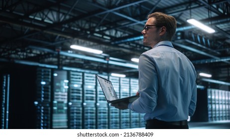 Data Center Male It Specialist Using Laptop while Working on Computer. Information Technology Professional. Server Farm Cloud Computing and Cyber Security Maintenance Concept