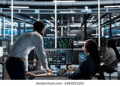 Data center manager supervises engineer using AI visual programming to optimize gear. Server farm team leader overseeing work done by worker colleagues using artificial intelligence analysis software
