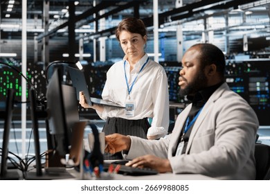 Data center manager supervising engineer inspecting gear, doing maintenance tasks. Server farm team leader supervising employee conducting system checks to ensure operational stability across rigs