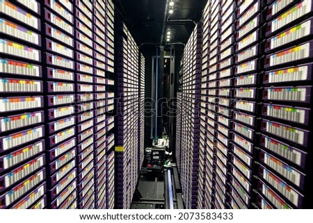 Data center with multiple rows of fully operational server racks. modern cloud computing technology concept.
