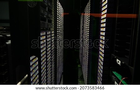 Data center with multiple rows of fully operational server racks. modern cloud computing technology concept.