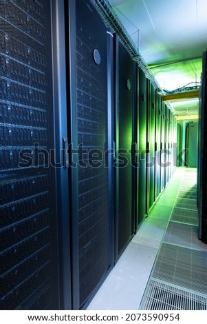 Data center with multiple rows of fully operational server racks. modern cloud computing technology concept.