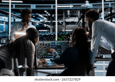 Data center programmers doing brainstorming, setting up machine learning systems handling information. Teamworking colleagues training neural networks to improve server farm operations