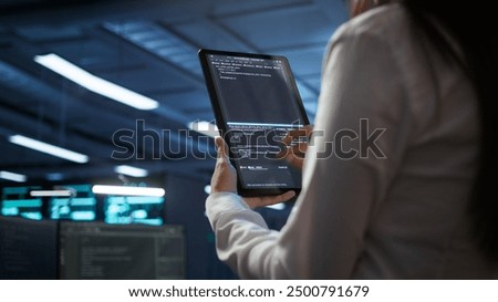Data center software developer responsible for installation of networking equipment solving tasks on device. Close up of woman doing maintenance on server room infrastructure using tablet, camera B