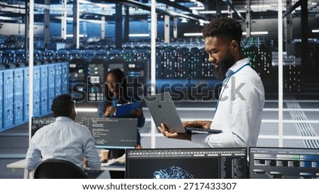 Data center system administrator analyzing infrastructure issues using node tree tools. Man in server hub using AI visualization insights on laptop to optimize system health, camera A