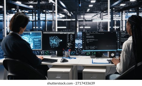 Data center system administrators using machine learning algorithms on PC to analyze datasets. Server farm employees using AI neural networks on devices to recognize data patterns, camera A