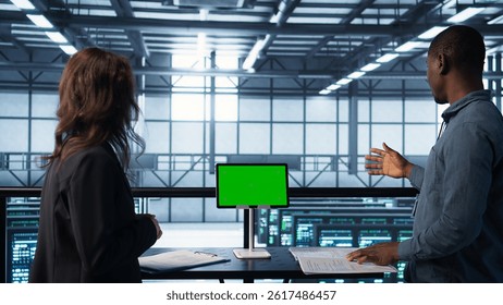 Data center team using mockup green screen tablet, reviewing paperwork files, and security protocols. Server room admins next to chroma key device analyzing critical system reports, camera B