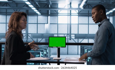 Data center team using mockup green screen tablet, reviewing paperwork files, and security protocols. Server room admins next to chroma key device analyzing critical system reports, camera A
