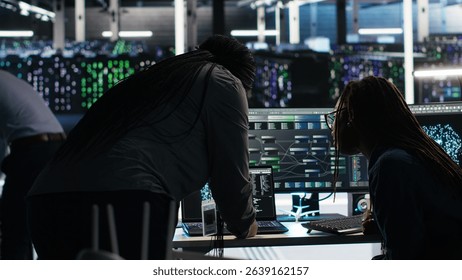 Data center teamworking colleagues use node tree program to identify equipment performance issues. Server hub engineering team coworkers review data analysis graph to minimize failures, camera B