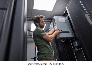 Data center technician installing server hardware and cabling in a server rack during maintenance work - Powered by Shutterstock - Get 15% off with code: PIKWIZARD15