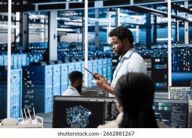 Data center technician using artificial intelligence visualization tools to identify infrastructure malfunctions. Server farm specialist looking at AI generated insights to detect hardware failures