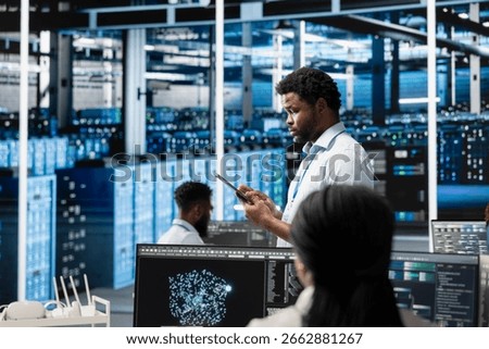Data center technician using artificial intelligence visualization tools to identify infrastructure malfunctions. Server farm specialist looking at AI generated insights to detect hardware failures