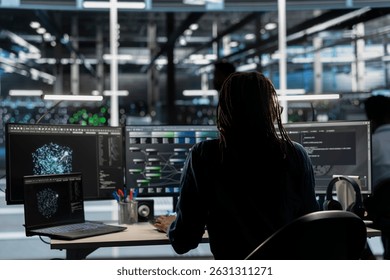 Data center worker using AI deep learning algorithms to analyze large datasets. Server farm technician using artificial intelligence and visual programming to recognize patterns in facility data