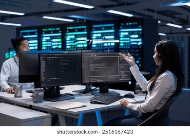Data center workers in remote call, providing customer support, troubleshooting damages. Coworkers in server hub carrying out operational interventions requested by clients, using microphone